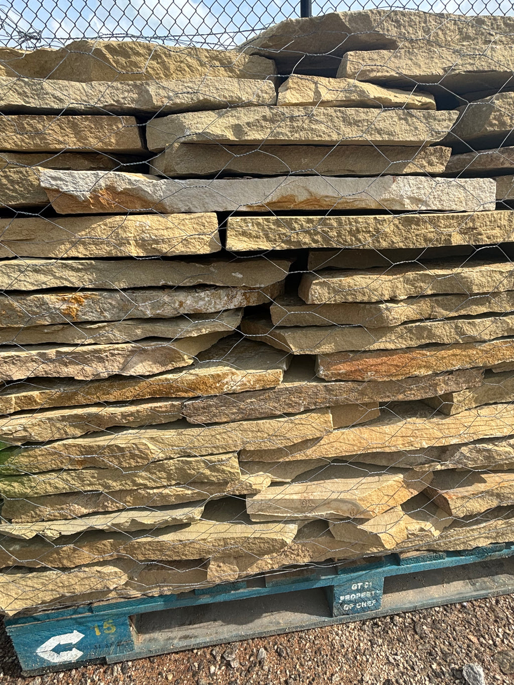 Tan and brown 1.5 inch flagstone stacked on a pallet at 9 Oak in Jenkinsburg Georgia