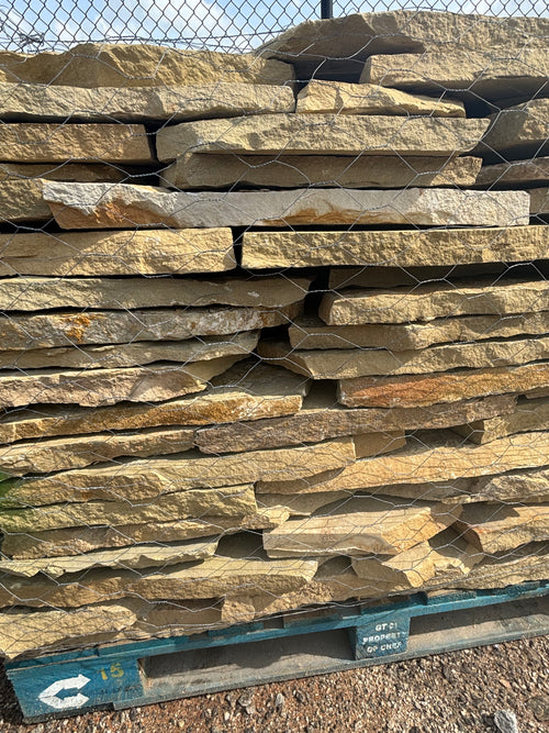 Tan and brown 1.5 inch flagstone stacked on a pallet at 9 Oak in Jenkinsburg Georgia