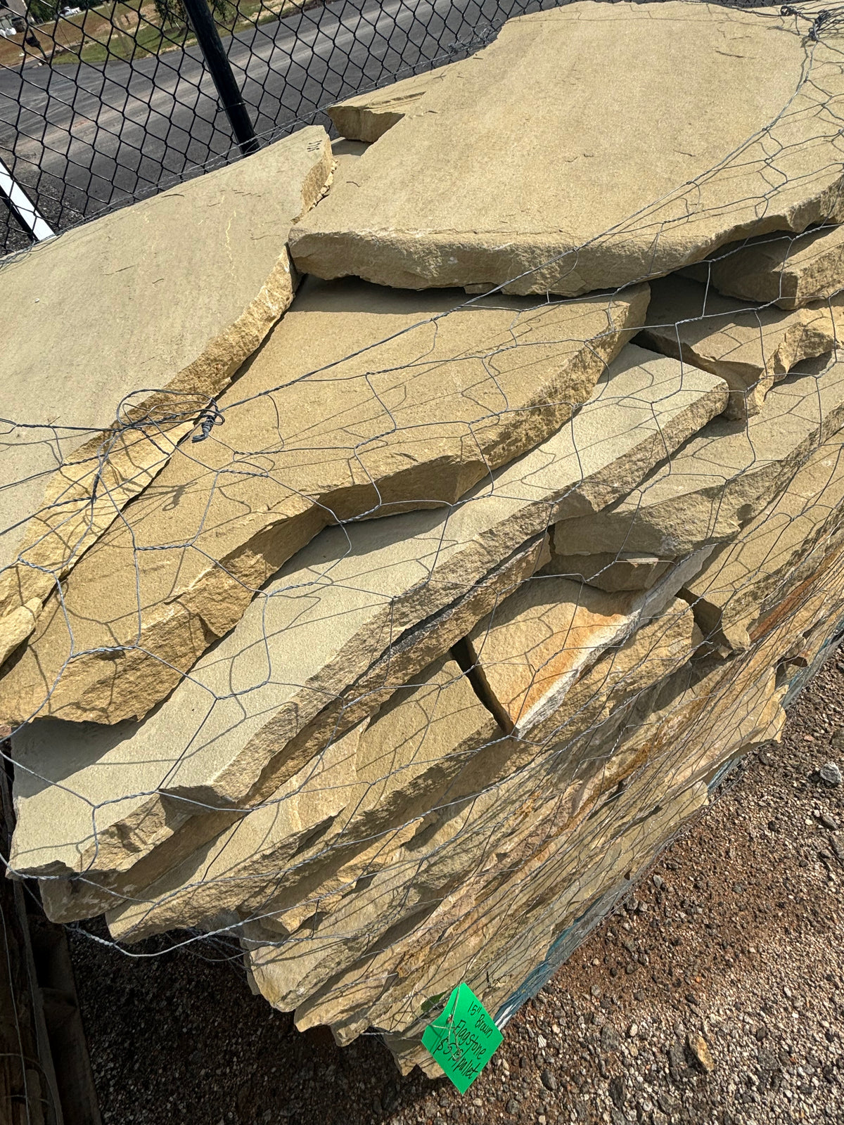 Tan and brown 1.5 inch flagstone stacked on a pallet at 9 Oak in Jenkinsburg Georgia