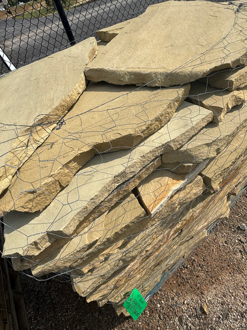 Tan and brown 1.5 inch flagstone stacked on a pallet at 9 Oak in Jenkinsburg Georgia